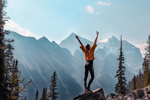 Blog - Premagovanje stresa - koliko CBD potrebujem? - Dekle je veselo, ko je premagalo stres in se povzpela na vrh hriba.